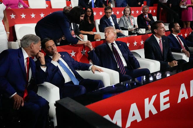 Donald Trump greets a guest in the family box during the third day of the Republican National Convention at Fiserv Forum. Texas Gov. Greg Abbott speaks to Sen. Marco Rubio at left, Virginia Gov. Glenn Youngkin and Donald Trump Jr. are seated at right. The third day of the RNC focused on foreign policy and threats.