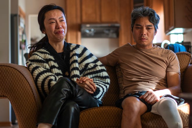 Jeff Wu, 47, of Lakeville, Minnesota listens as his wife Ting Yang, 41, gets emotional at their home on Thursday, December 7, 2023, while recalling the scene where her husband was struck by his vehicle after the gear shifter slipped crushing his leg.