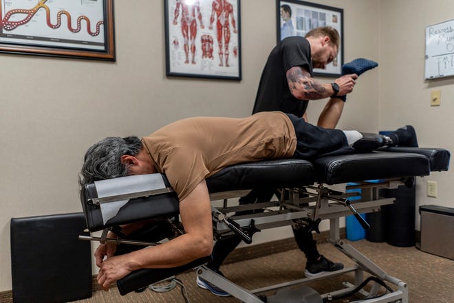 Jeffrey Wu, 47, of Lakeville, Minnesota, lies on the table as chiropractor Aaron Howe performs muscle work on Wu's hamstring during his appointment at Life Time Fitness, also in Lakeville on Thursday, December 7, 2023.