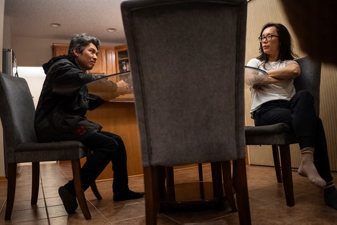 Jeffrey Wu, 47, of Lakeville, Minnesota, sits at the dinner table with his wife, Ting Yang, 41, in the early morning on Wednesday, December 6, 2023, as he prepares to go to work a late-night shift at a dairy plant.