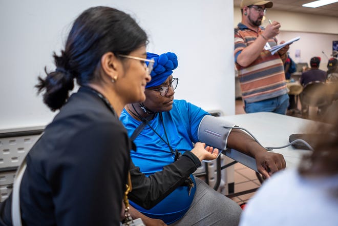 Community Health and Social Services family medicine physician Dr. Shaina Shetty, left, does a blood pressure check on Jackqueline Bowers, 51, of Detroit, during a stop to the Capuchin Soup Kitchen in Detroit while doing a street medicine outreach on Monday, August 12, 2024. CHASS recently received $562,868 in American Plan Act dollars to expand its street medicine team, to aid people experiencing homelessness on the streets taking medical care right to the people who need it.