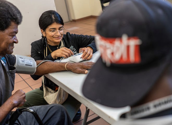 Community Health and Social Services family medicine physician Dr. Shaina Shetty does a blood pressure check for Moses Thomas, 70, of Detroit, during a stop to the Capuchin Soup Kitchen in Detroit while doing street medicine outreach on Monday, August 12, 2024. CHASS recently received $562,868 in American Plan Act dollars to expand its street medicine team, to aid people experiencing homelessness on the streets taking medical care right to the people who need it.